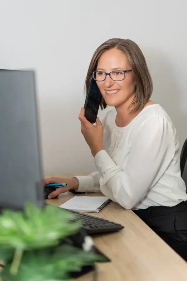 Smiling woman on phone at office computer